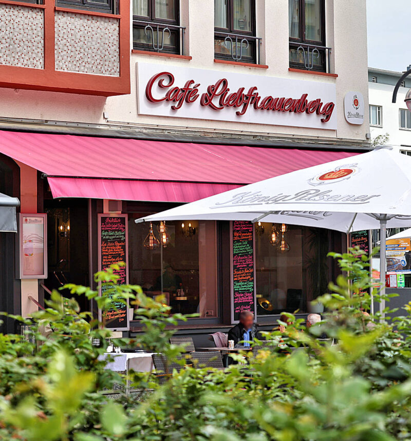 Café mit roten Markisen, Sonnenschirmen
